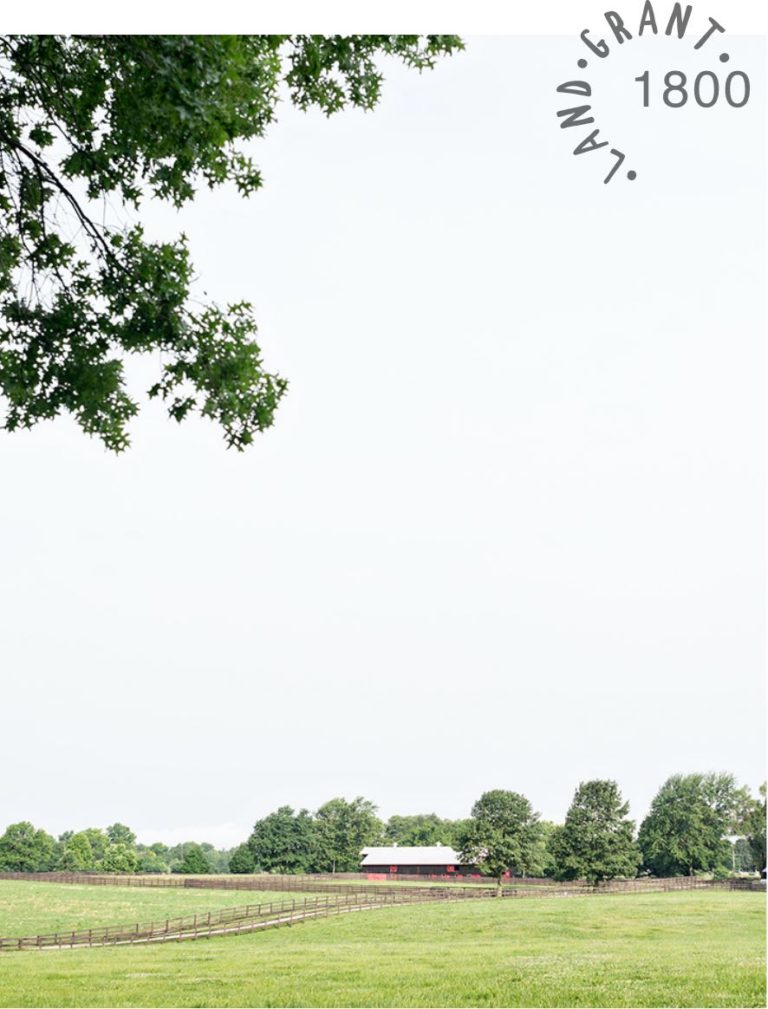 farm land with a barn and fence