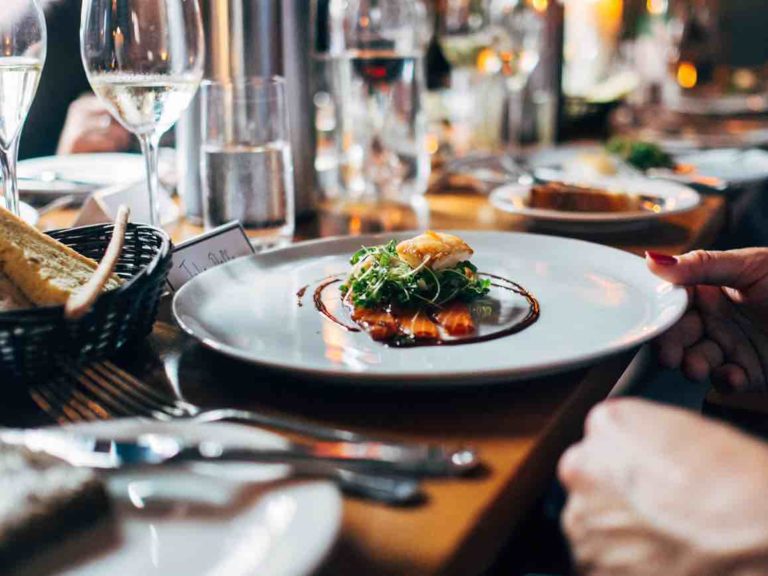 table set with plates of gourmet food and drinks